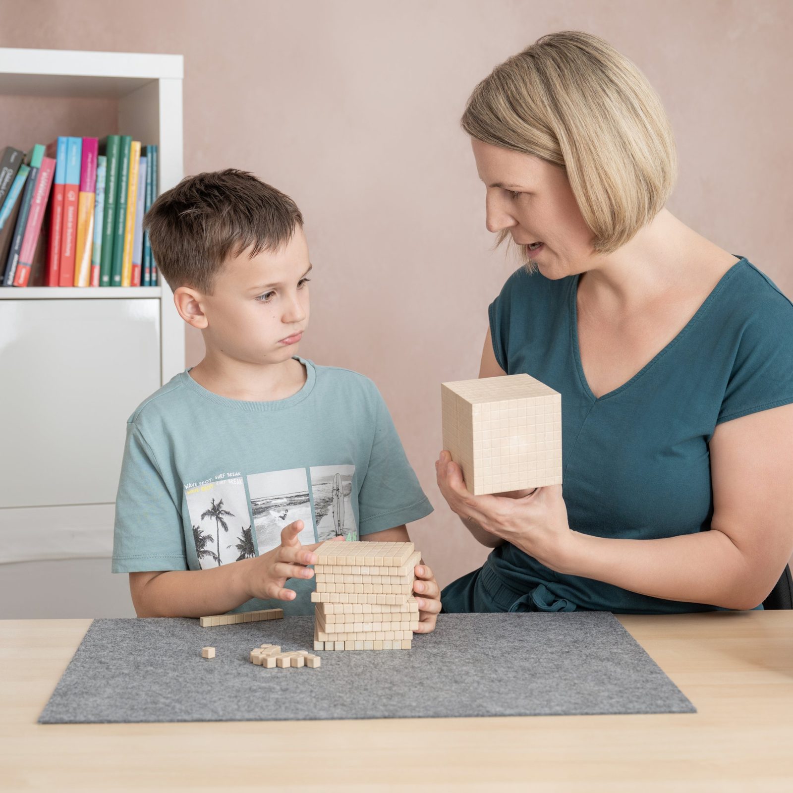 Andrea Karner erklärt einem Buben das Stellenwertsystem mit Holzwürfeln