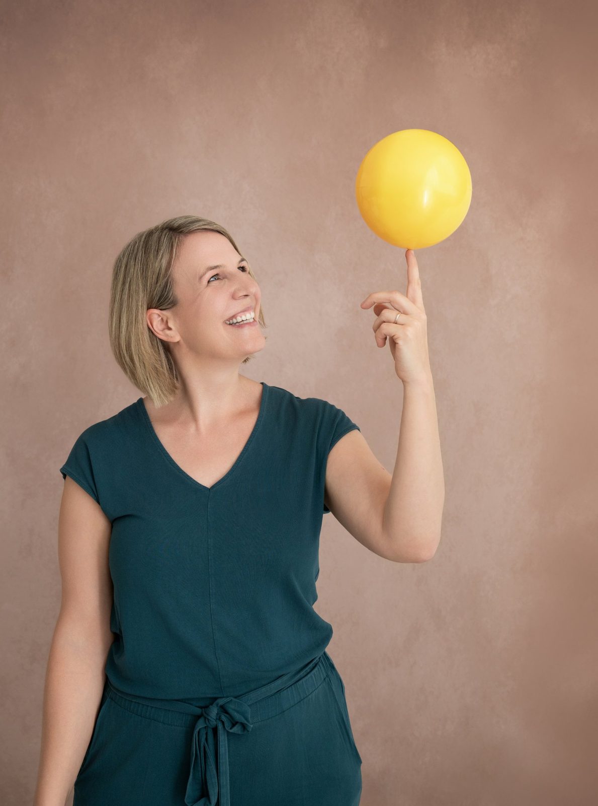 Andrea Karner balanciert einen gelben Ball auf dem Finger